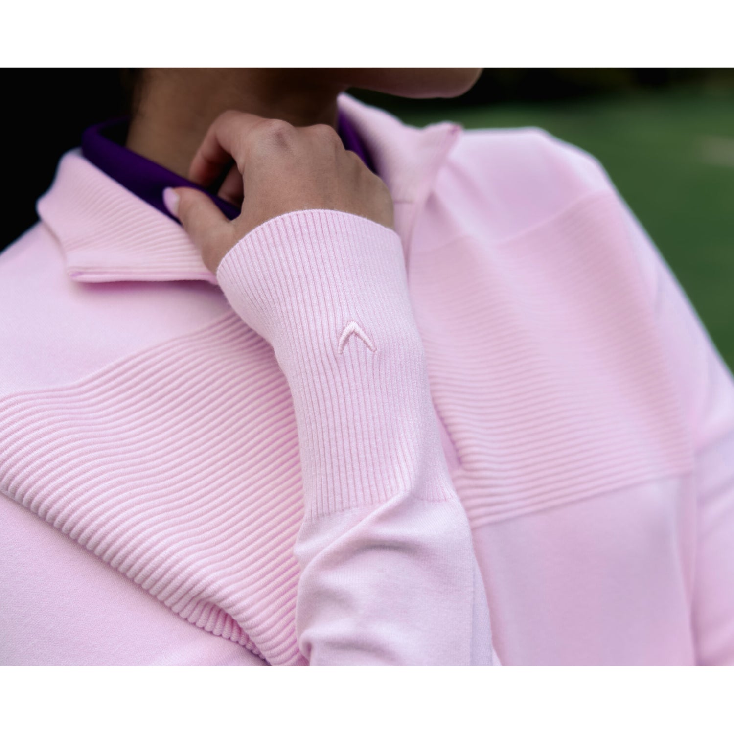 Gros plan de la texture en maille côtelée du pull zippé à col montant extensible Callaway Soft Stretch en Fleur de Cerisier