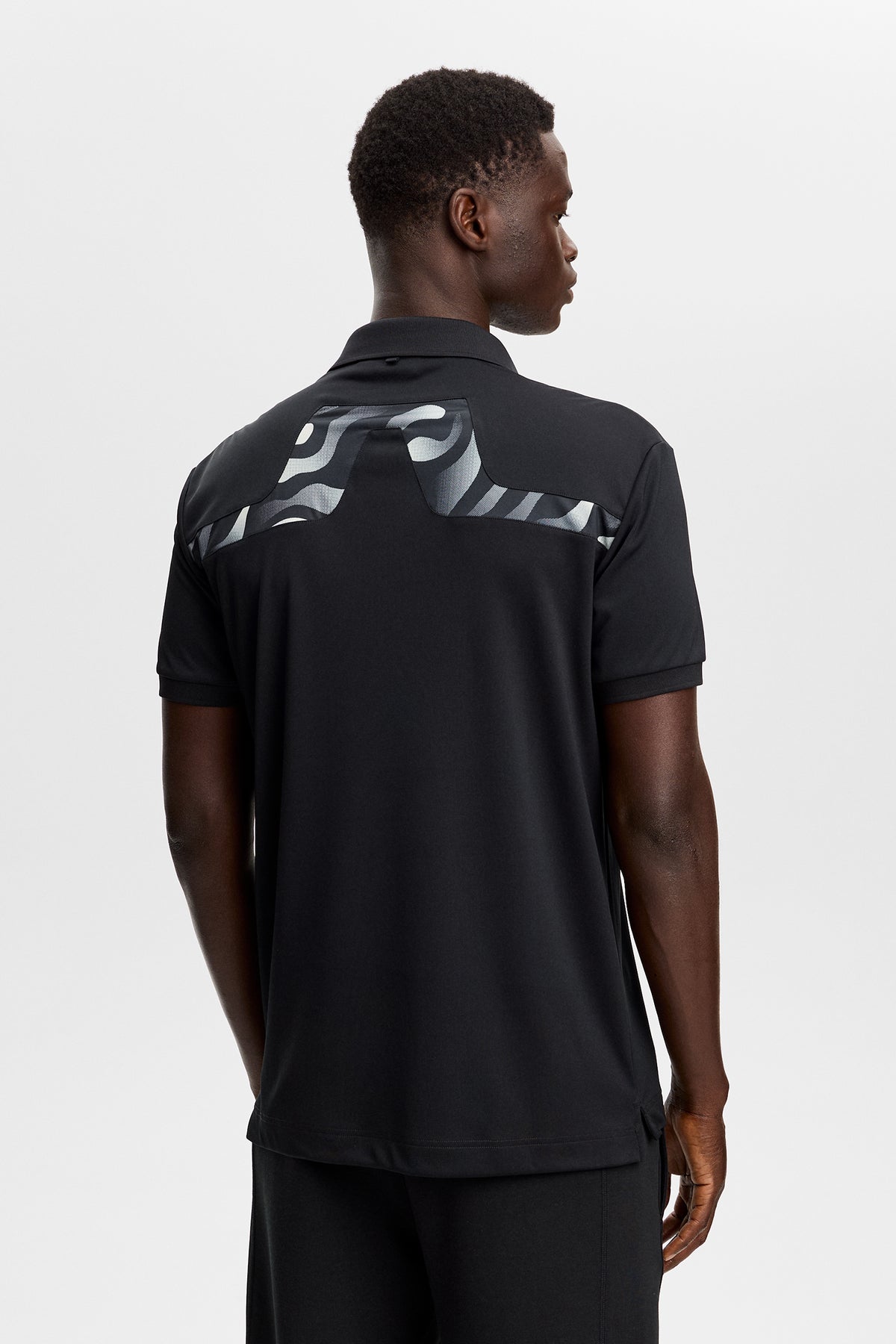 Polo J.Lindeberg KV Print Noir – photo de style de vie sur le parcours démontrant la protection solaire UPF 40+
