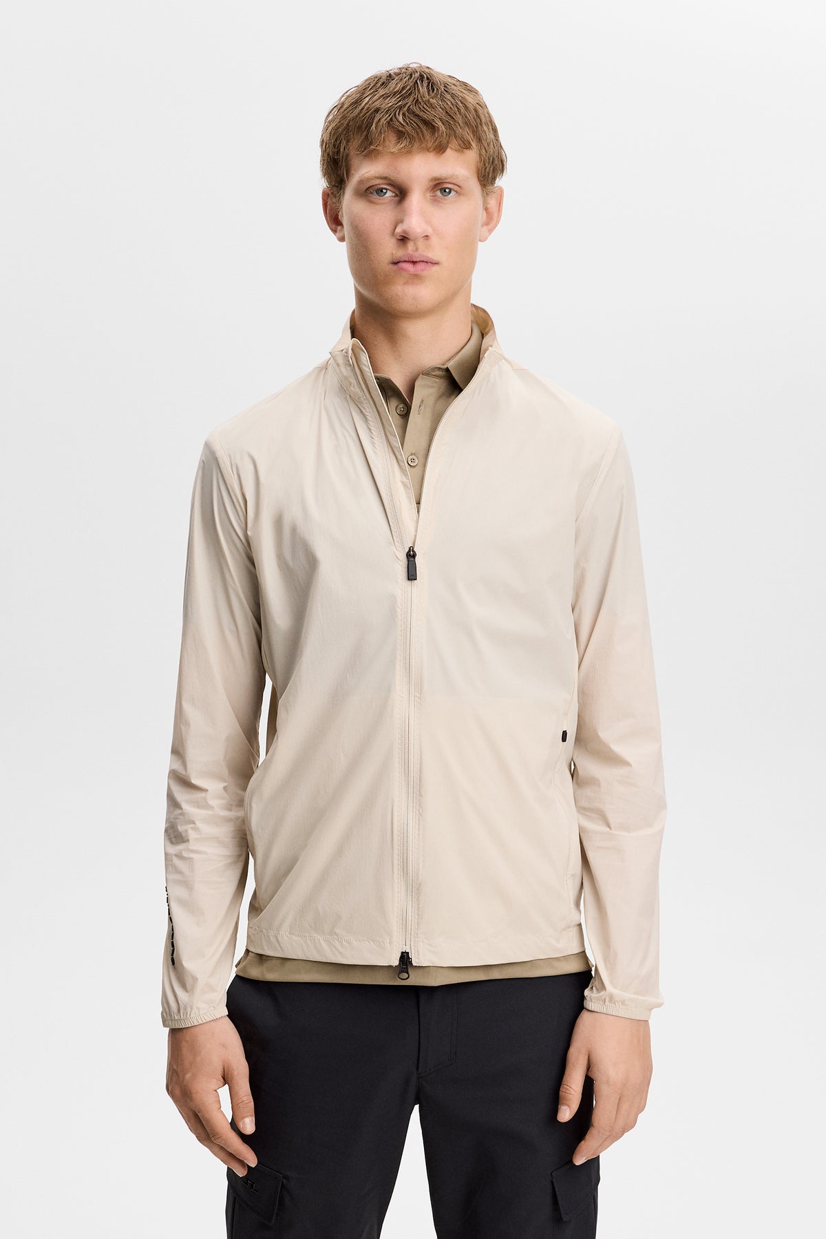 Détail avant de la veste packable J.Lindeberg Tour Tech Moonbeam montrant le tissu Flex Tech 2.0 et la fermeture éclair